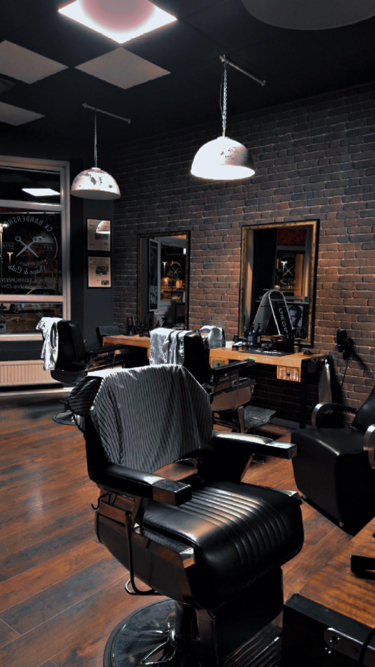 Salongen hos CK Barbershop med barberarstolar och tegelvägg
